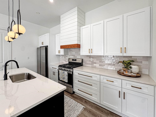 kitchen featuring a sink, white cabinets, tasteful backsplash, and stainless steel appliances