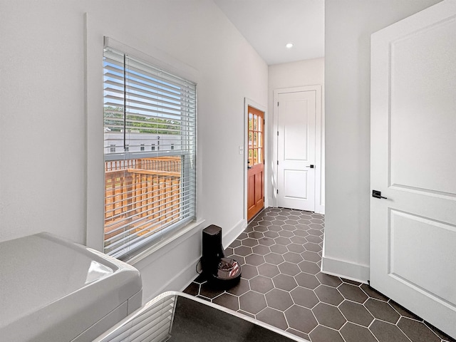 hall with dark tile patterned floors, recessed lighting, and baseboards