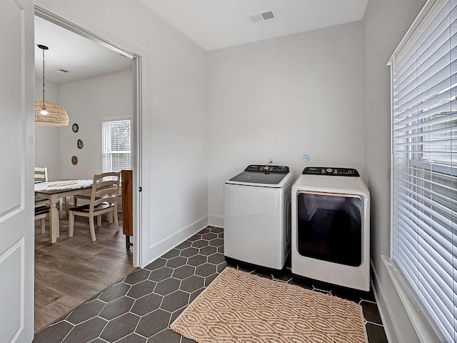 clothes washing area featuring separate washer and dryer, baseboards, laundry area, and visible vents