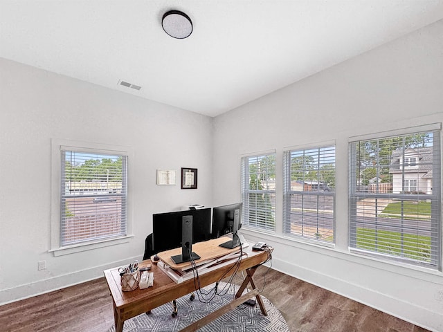 office space with visible vents, baseboards, wood finished floors, and a healthy amount of sunlight
