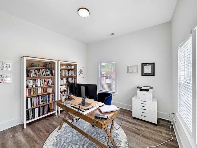 office featuring baseboards, visible vents, and wood finished floors