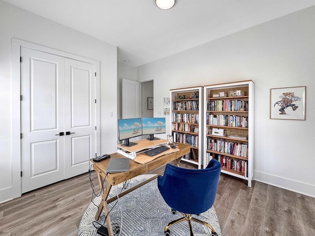 home office with baseboards and wood finished floors