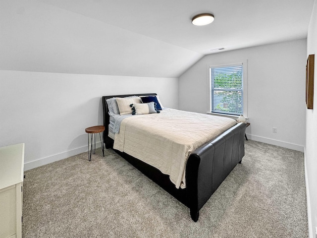 carpeted bedroom with baseboards, vaulted ceiling, and visible vents