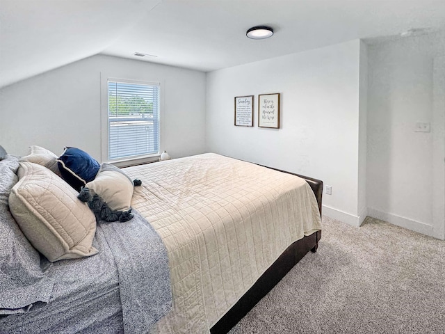 carpeted bedroom featuring baseboards, visible vents, and vaulted ceiling