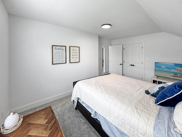 bedroom featuring baseboards, lofted ceiling, carpet, and a closet