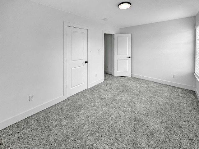 unfurnished bedroom featuring baseboards and carpet flooring