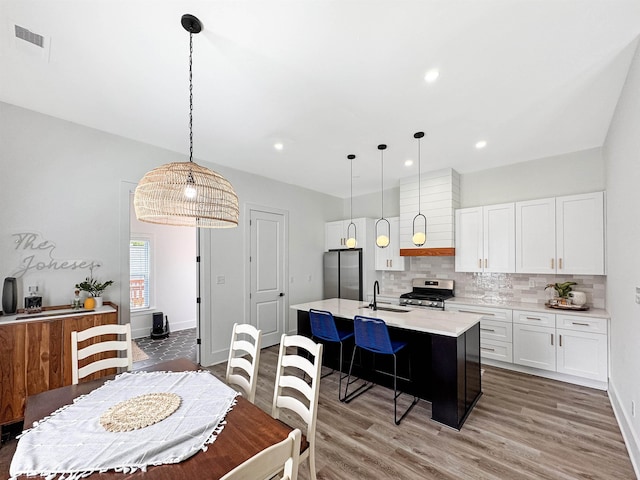 dining area featuring light wood-type flooring, recessed lighting, baseboards, and visible vents