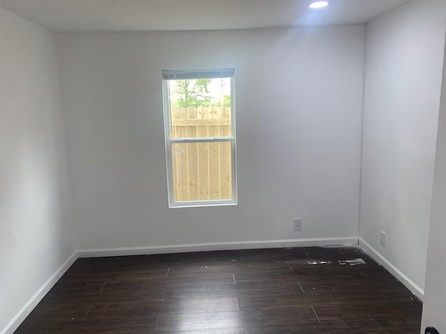 spare room featuring baseboards, recessed lighting, and dark wood-style flooring