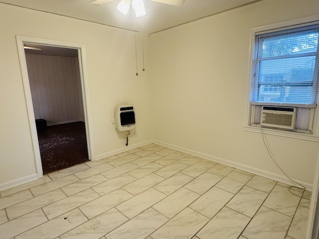empty room with heating unit, baseboards, cooling unit, and a ceiling fan