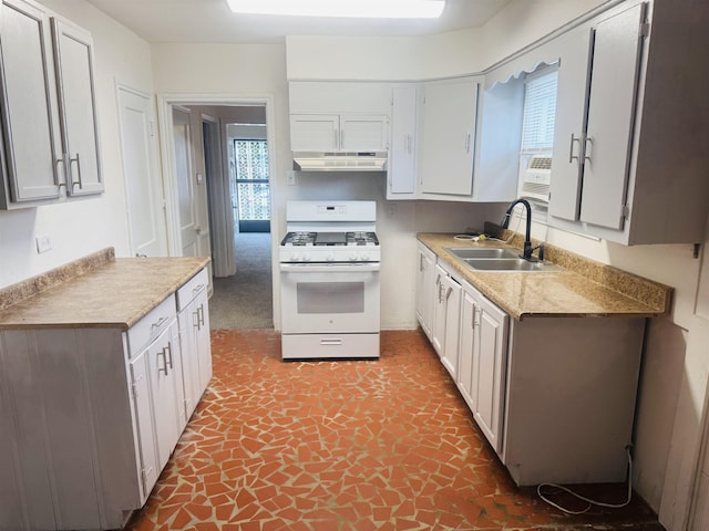 kitchen with plenty of natural light, gas range gas stove, a sink, and under cabinet range hood