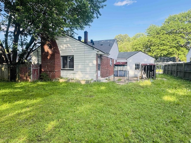 back of house with fence, a chimney, and a yard