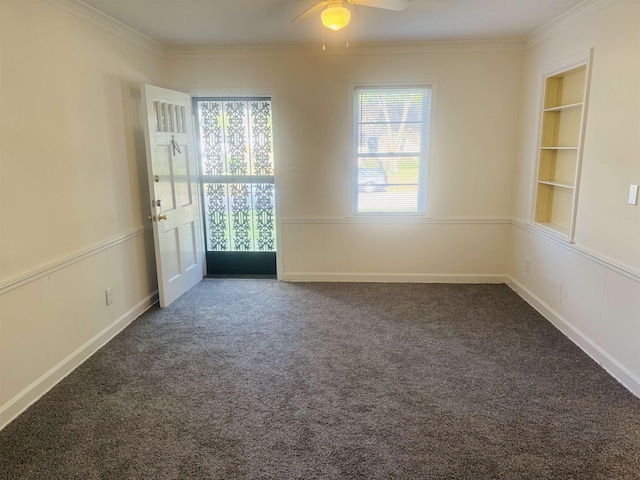 empty room featuring carpet flooring, built in features, a ceiling fan, and ornamental molding
