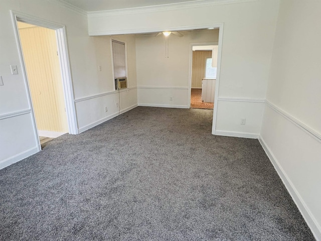carpeted spare room featuring ceiling fan, ornamental molding, baseboards, and cooling unit