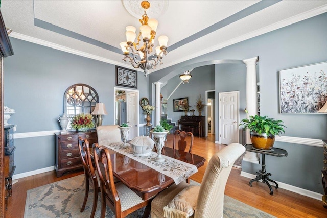 235 Fairoaks Dr, Oakland, TN 38060 - dining room featuring a raised ceiling, arched walkways, a chandelier, baseboards, and wood finished floors