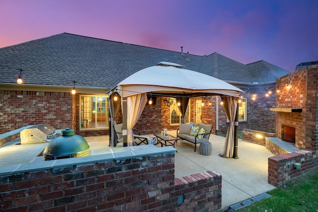 view of patio featuring a gazebo and an outdoor living space with a fireplace