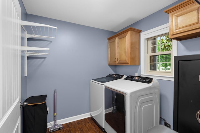 laundry room featuring baseboards, independent washer and dryer, cabinet space, and dark wood-type flooring