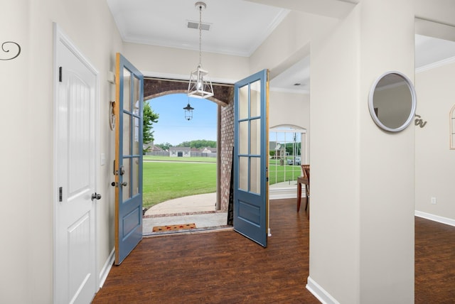 foyer entrance with visible vents, ornamental molding, baseboards, and wood finished floors