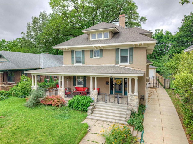 american foursquare style home featuring a front yard, roof with shingles, a chimney, a gate, and a porch