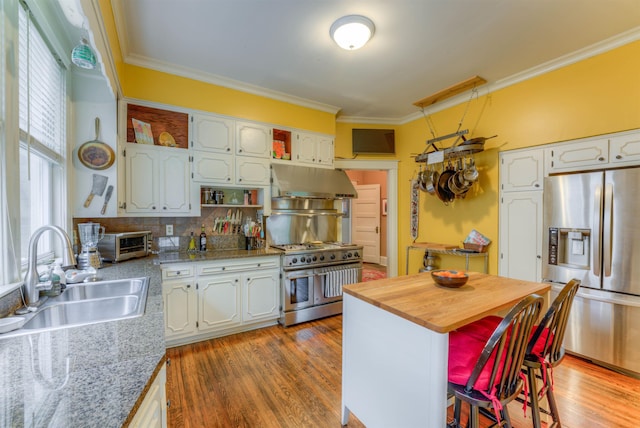 kitchen with open shelves, ornamental molding, under cabinet range hood, a sink, and stainless steel appliances