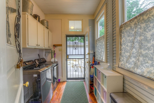 laundry area with cabinet space, wood finished floors, and washer and dryer