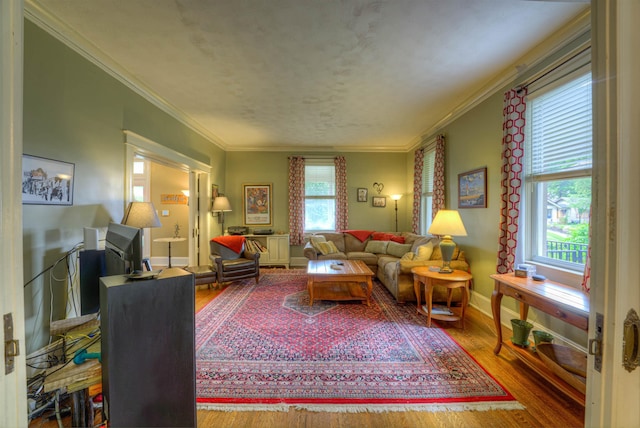 living room featuring baseboards, ornamental molding, and wood finished floors