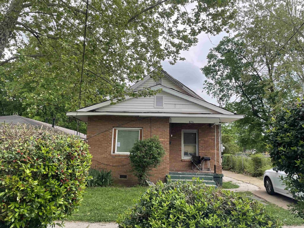 bungalow featuring brick siding, covered porch, and crawl space