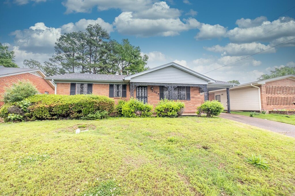 2364 Rozelle St, Memphis, TN 38114 - single story home with brick siding, an attached carport, driveway, and a front yard