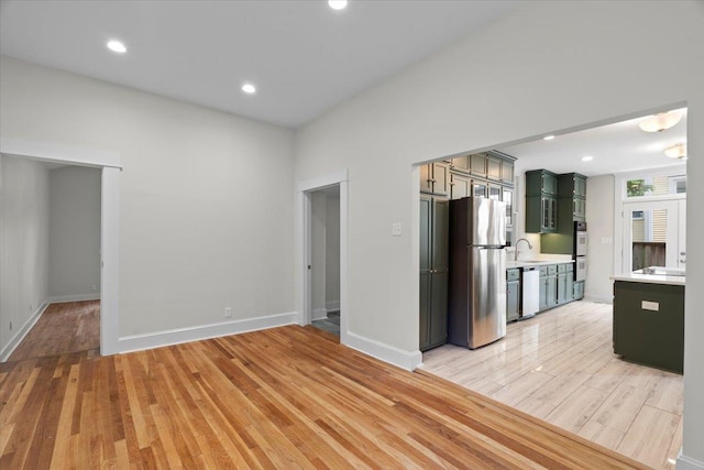 1682 Lawrence Ave, Memphis, TN 38112 - kitchen with a sink, dishwasher, light countertops, freestanding refrigerator, and green cabinets