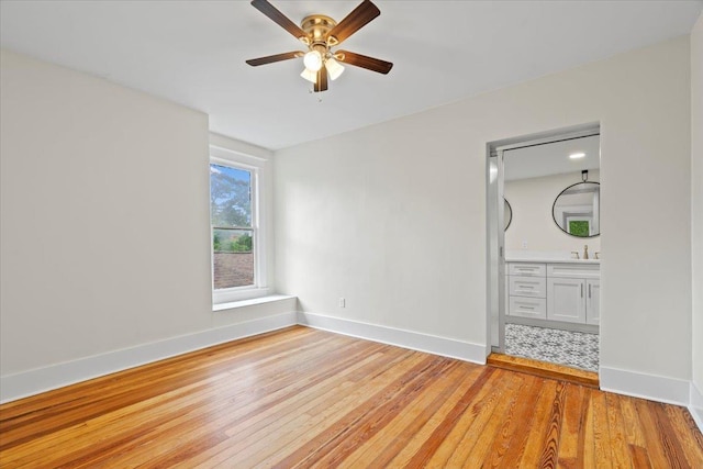 1682 Lawrence Ave, Memphis, TN 38112 - unfurnished bedroom featuring connected bathroom, ceiling fan, a sink, light wood-style flooring, and baseboards