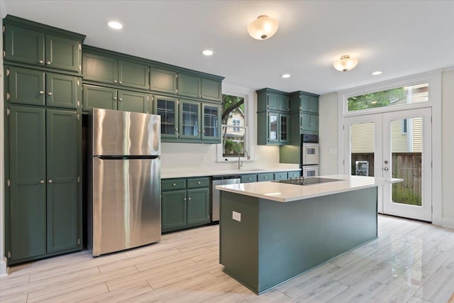 1682 Lawrence Ave, Memphis, TN 38112 - kitchen featuring light wood-style floors, green cabinetry, stainless steel appliances, and a wealth of natural light