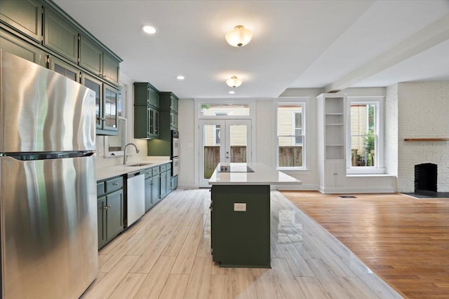 1682 Lawrence Ave, Memphis, TN 38112 - kitchen with a sink, light countertops, green cabinetry, and stainless steel appliances