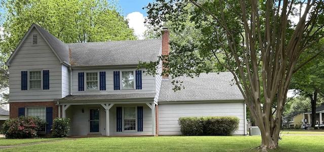 traditional home featuring covered porch, a chimney, roof with shingles, central AC, and a front lawn