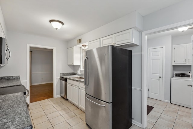 kitchen with white cabinets, appliances with stainless steel finishes, washer / clothes dryer, light tile patterned floors, and visible vents