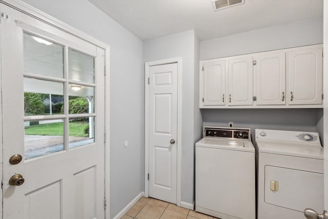 washroom featuring cabinet space, light tile patterned flooring, washing machine and clothes dryer, baseboards, and visible vents
