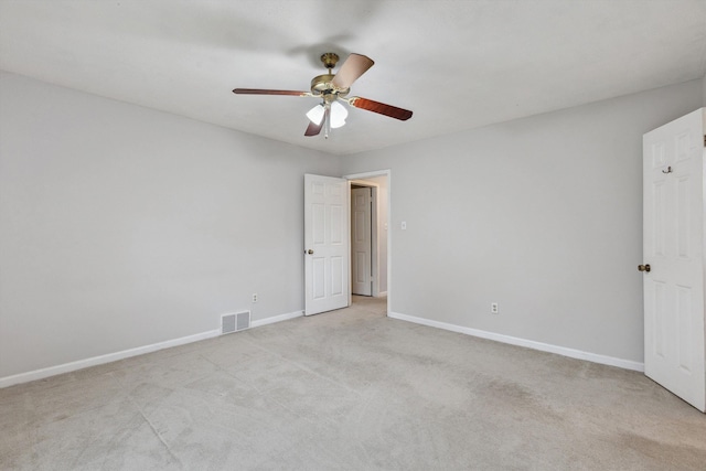 empty room featuring visible vents, a ceiling fan, baseboards, and light colored carpet