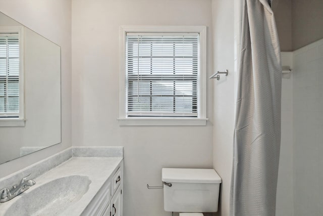 bathroom with plenty of natural light, a shower with shower curtain, and vanity