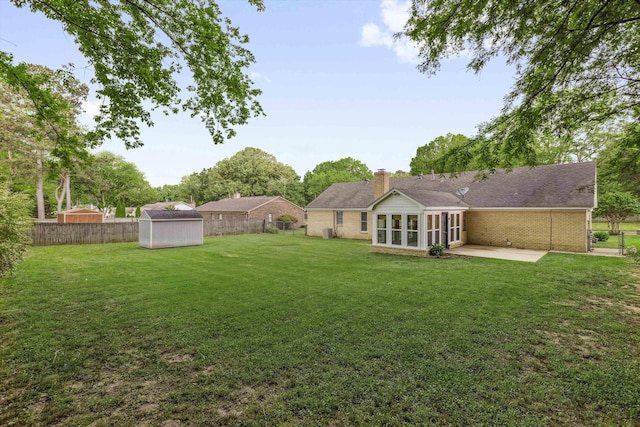 view of yard featuring a fenced backyard, a patio area, a storage shed, and an outbuilding