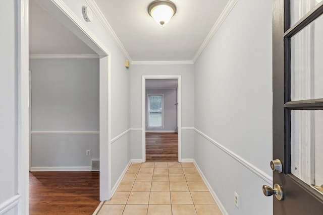 interior space with baseboards, ornamental molding, and light wood-type flooring