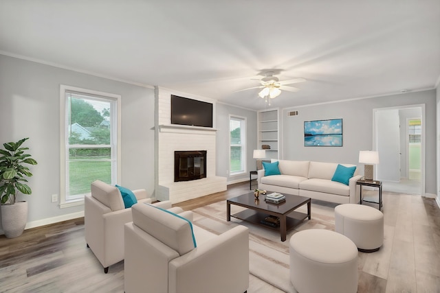 living room with ornamental molding, wood finished floors, and a wealth of natural light