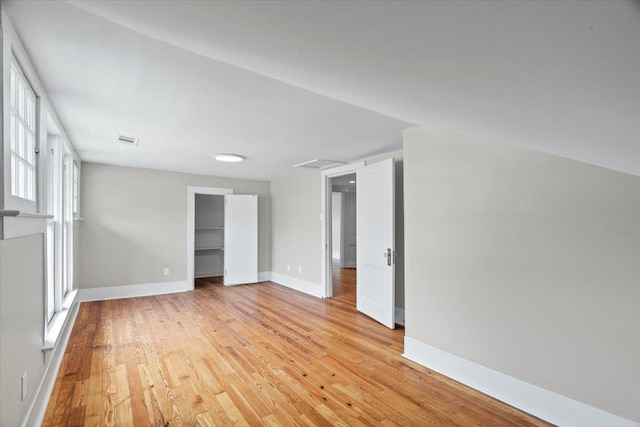 interior space featuring baseboards, light wood-type flooring, and visible vents