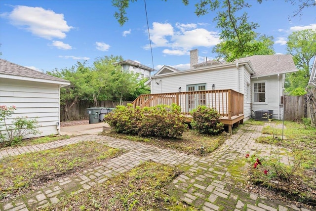 back of house with fence, cooling unit, a wooden deck, and a chimney