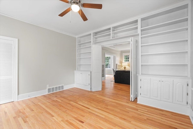 spare room featuring ceiling fan, visible vents, crown molding, light wood-type flooring, and built in shelves