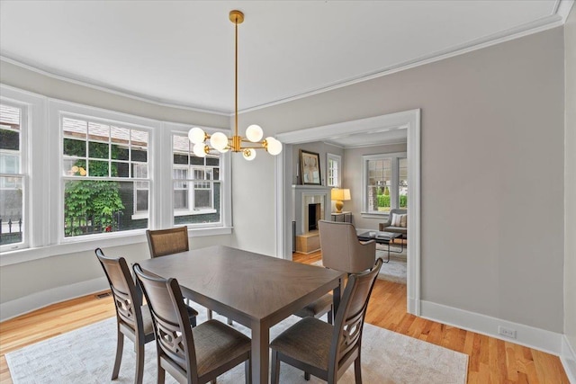 dining room with crown molding, baseboards, plenty of natural light, and a chandelier