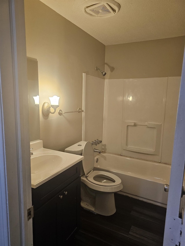 bathroom with vanity, toilet, shower / bath combination, wood finished floors, and visible vents