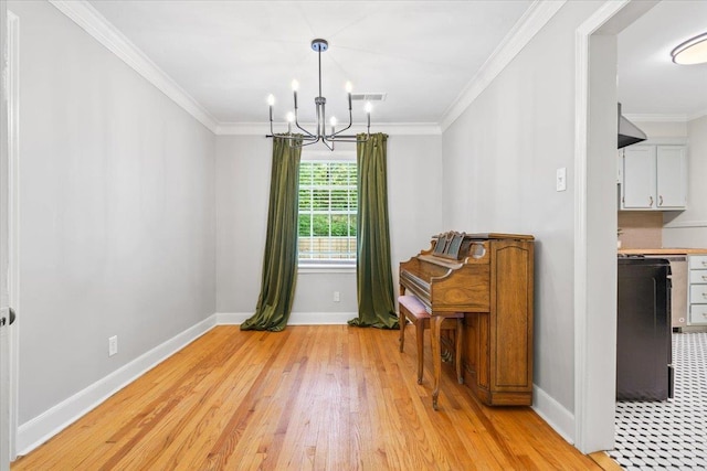 dining space with baseboards, ornamental molding, light wood finished floors, and a chandelier