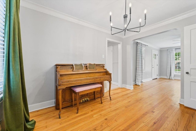 sitting room with an inviting chandelier, ornamental molding, baseboards, and light wood-type flooring