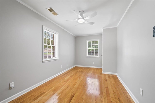 unfurnished room featuring visible vents, a ceiling fan, light wood-style flooring, and crown molding