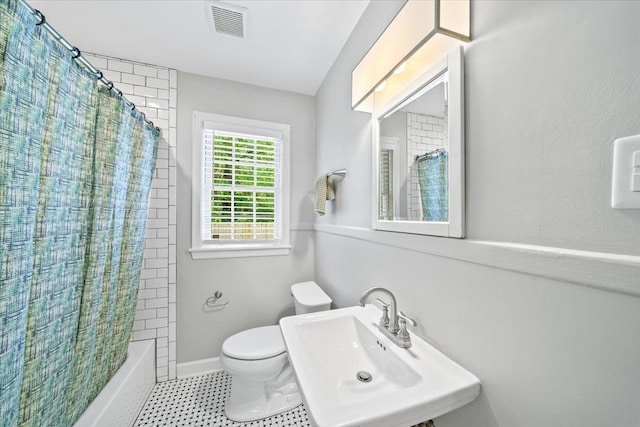 bathroom featuring a sink, toilet, tile patterned floors, shower / bath combination with curtain, and visible vents
