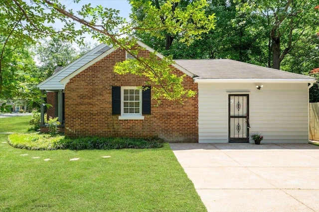 view of front facade featuring brick siding, a shingled roof, and a front lawn