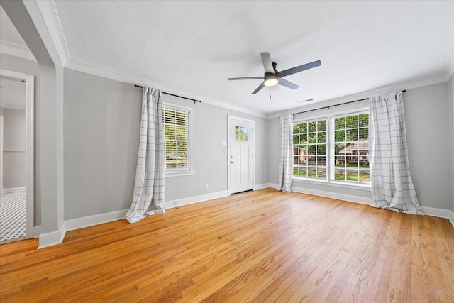 unfurnished room with baseboards, a ceiling fan, light wood finished floors, and a wealth of natural light